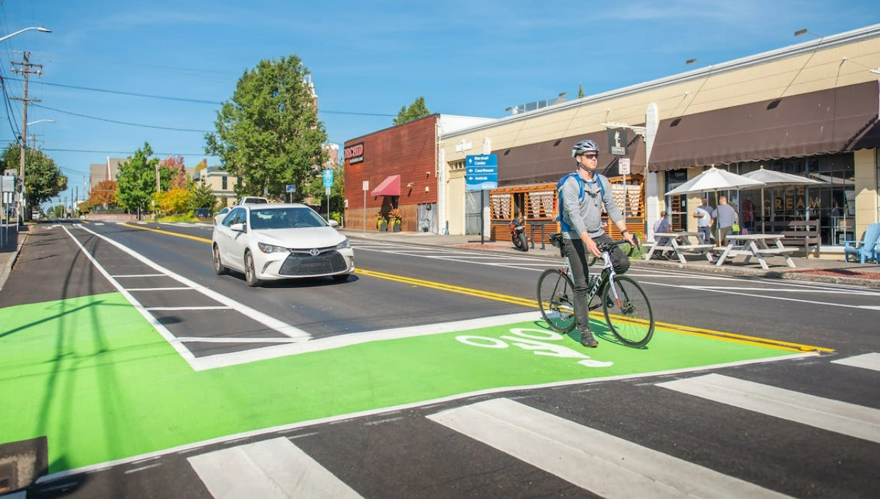 Bike in green bike line in front of a car