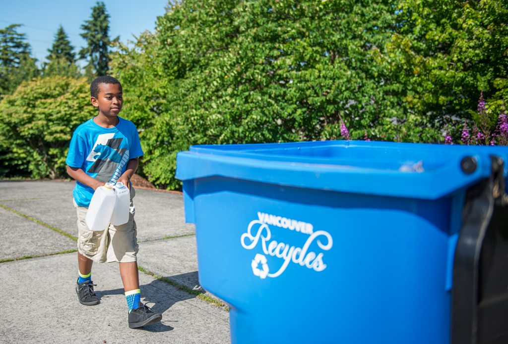 Boy using recycling bin