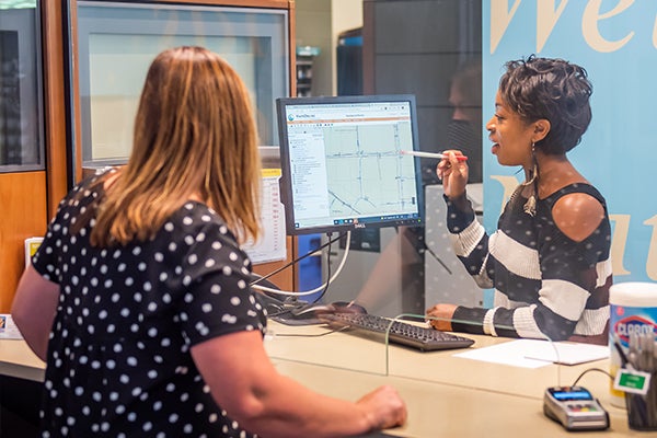 customer at permit center counter speaking to a staff person and looking at screen