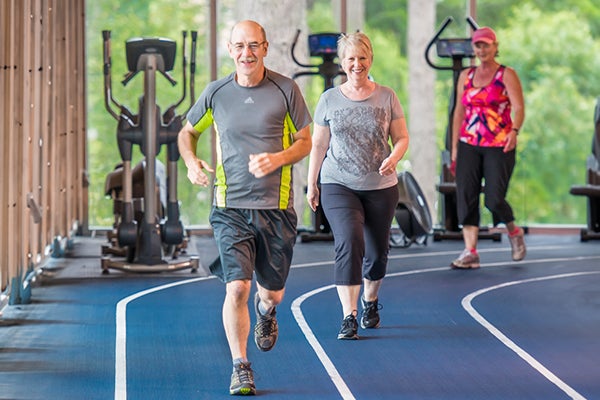 three people using indoor track at community center