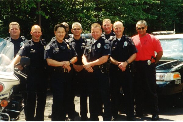 Pictured, the Vancouver Police Department Traffic Team, in June of 2002. From left: Officer Steve Donahue, Corporal Robert Schoene, Sergeant Timothy Kim, Officer Jeffrey Starks (back row), Officer Steve Cappellas, Officer Jim White, Officer Patrick Johns, Officer Ron Rose, Officer Navin Sharma. Between the years 2002-2004 the Traffic unit achieved zero road fatalities.