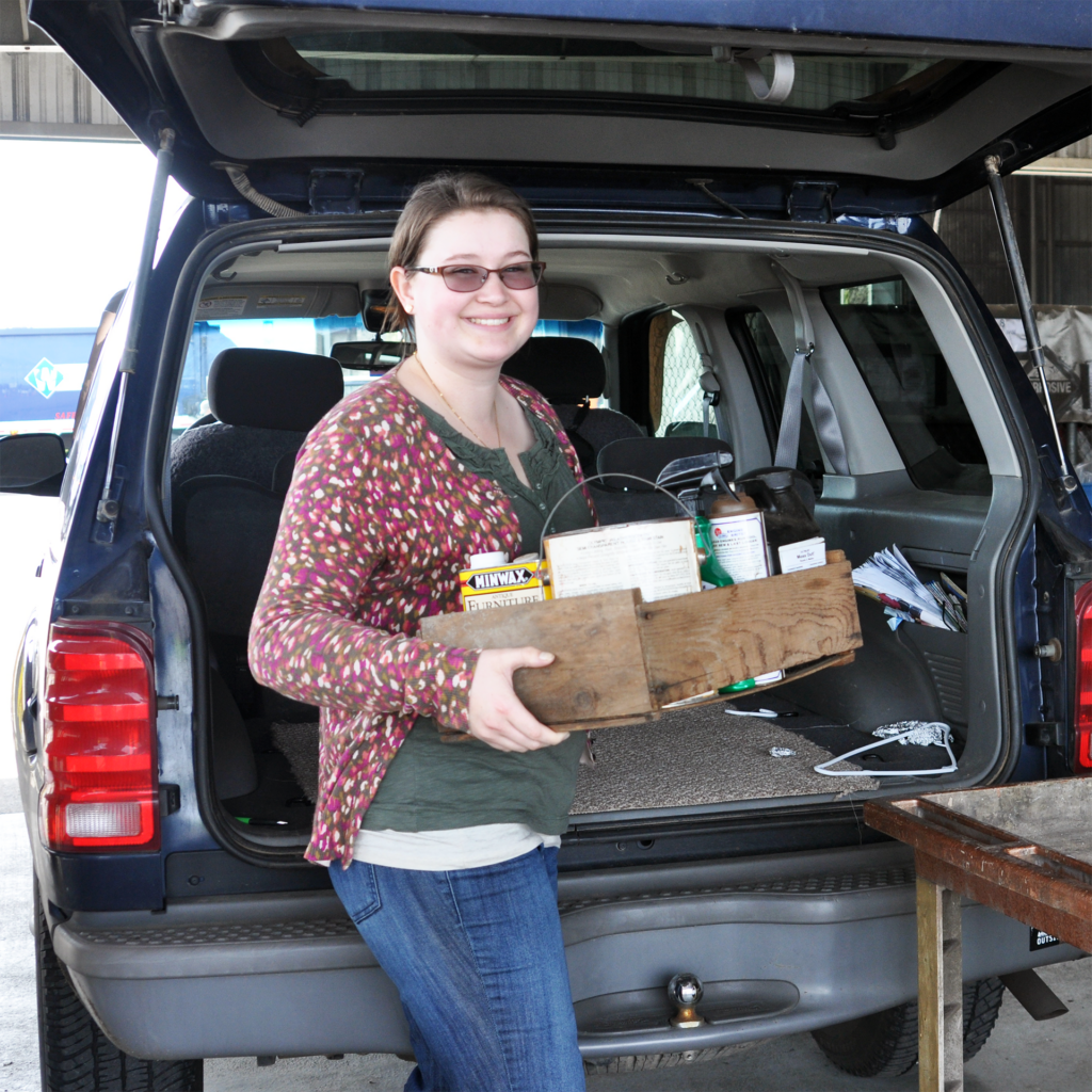 Woman is recycling beyond the curb at home by taking items to a local drop-off site