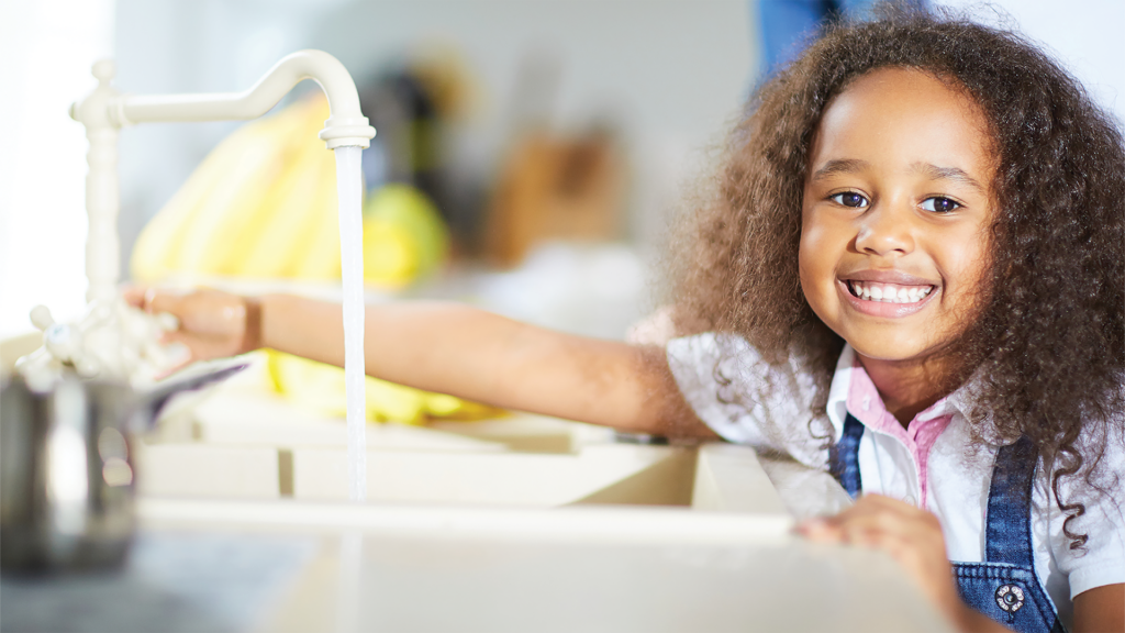 Girl running water at sink