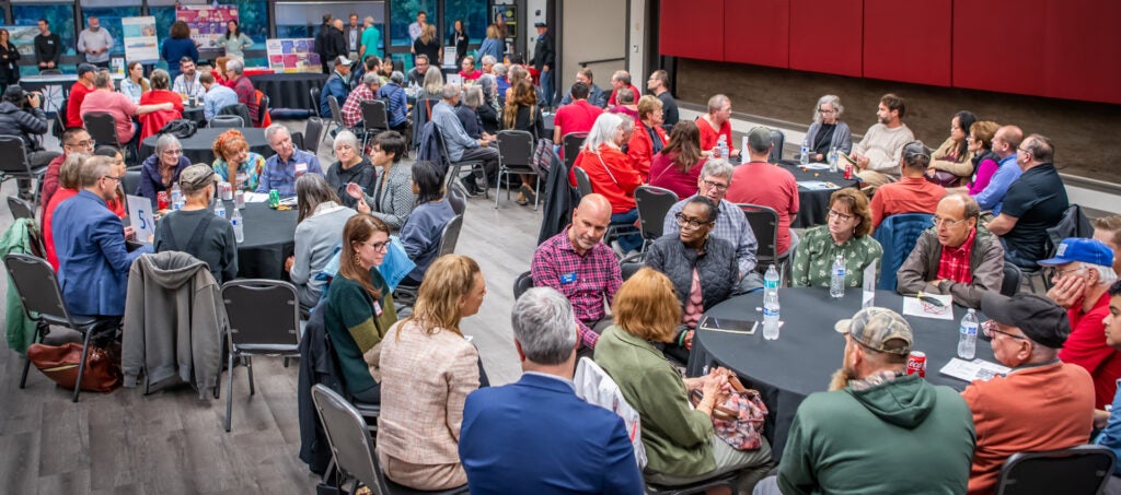 Community members and City Councilors sit at tables at the Luepke Center, during a Council Community Forum.