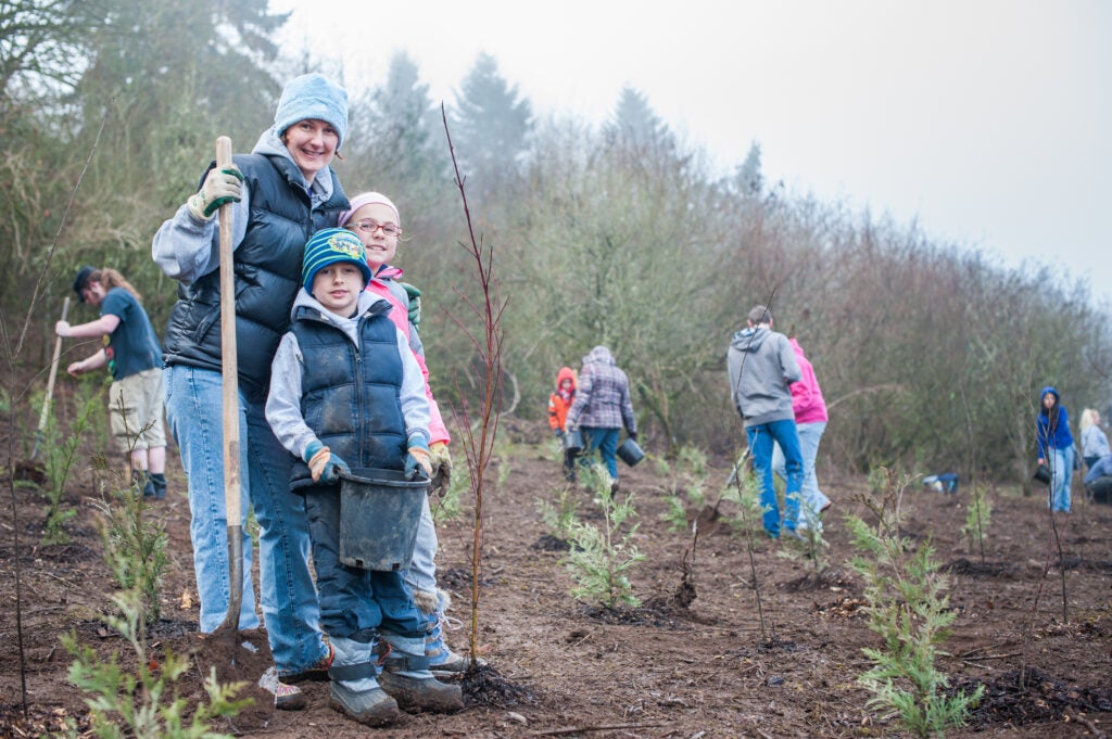 Family plant trees at Burnt Bridge Creek