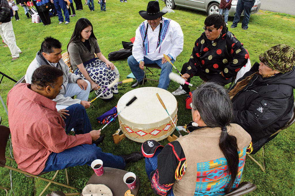 A group of Nez Perce tribe members playing a large drum.