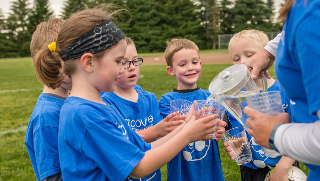 Children in a recreation league taking a water break