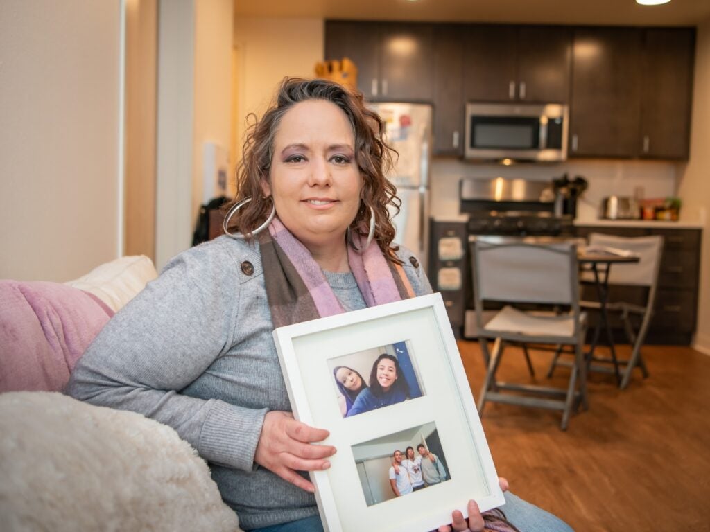 Tyauna sits in her new home on the fourth story of the Fourth Plain Community Commons holding photos of her four children. 