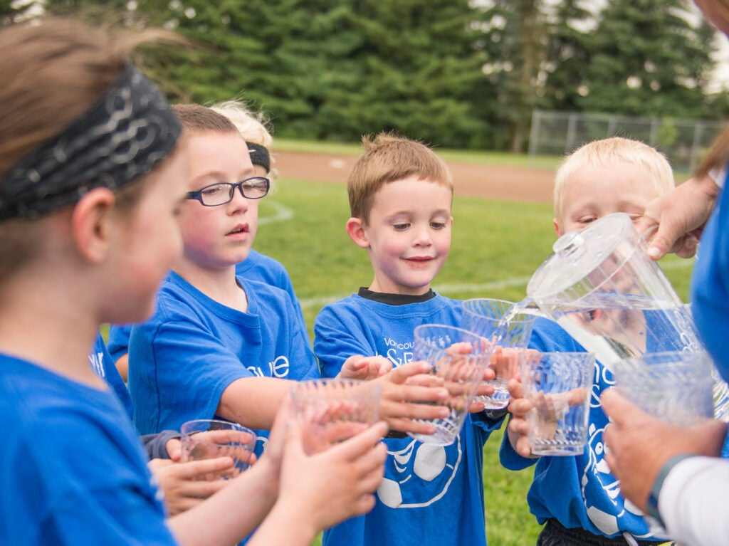 Kids on a soccer team drink water