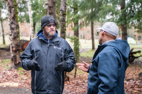 Lon Klugman, HART Homeless Outreach Specialist, talks to a community member at an encampment clean up