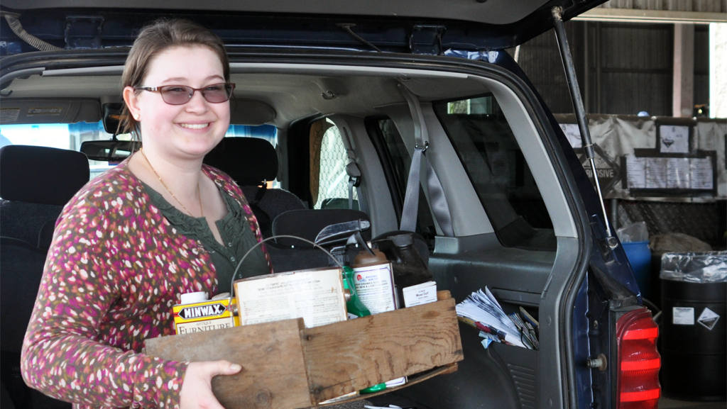 Woman is recycling beyond the curb at home by taking items to a local drop-off site