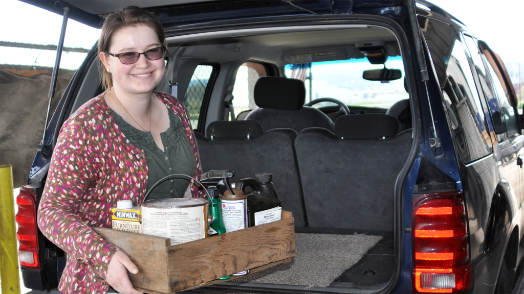 Woman is taking a box of items to a local drop-off site for proper recycling