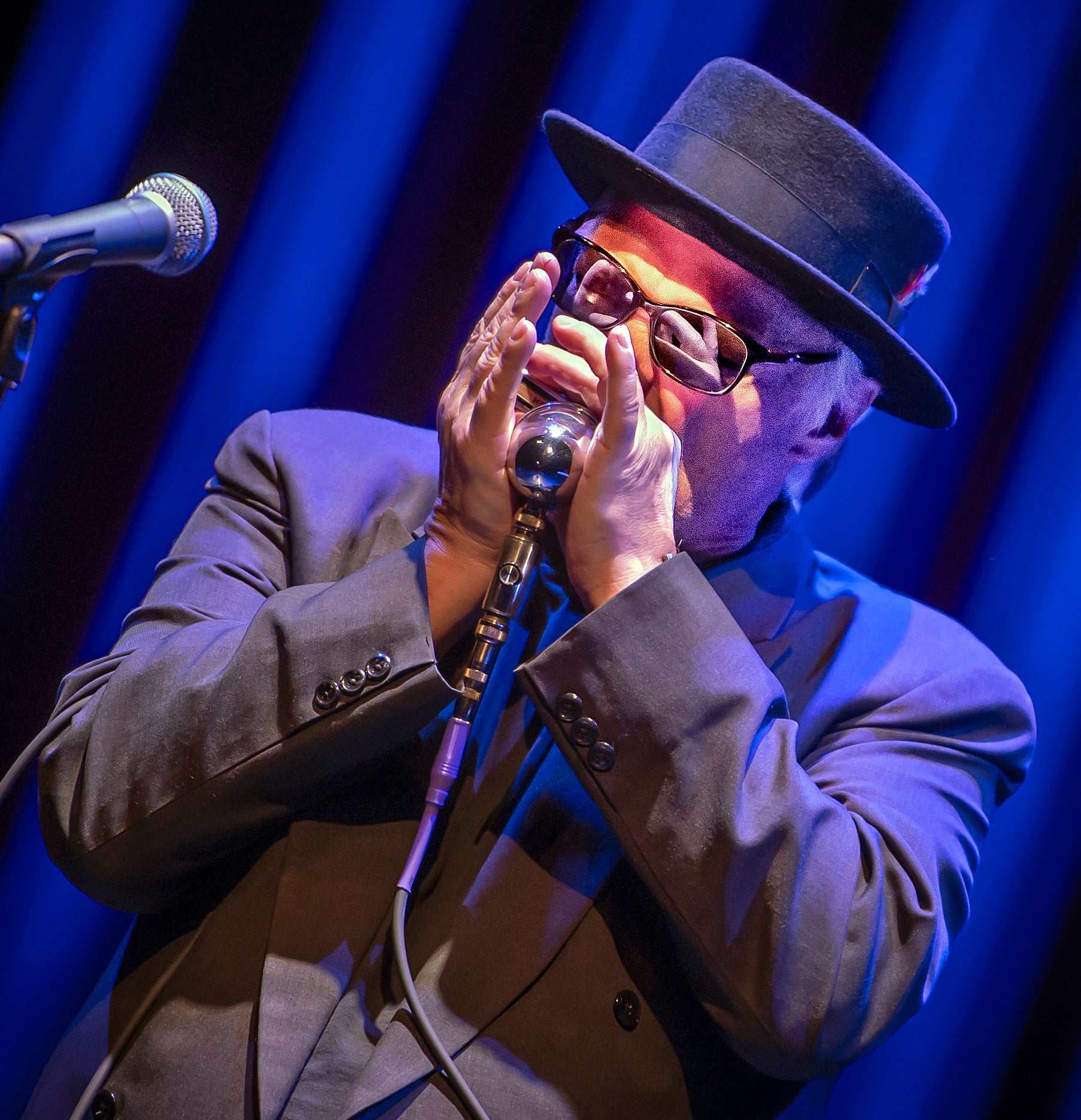 Curtis Salgado playing a harmonica.