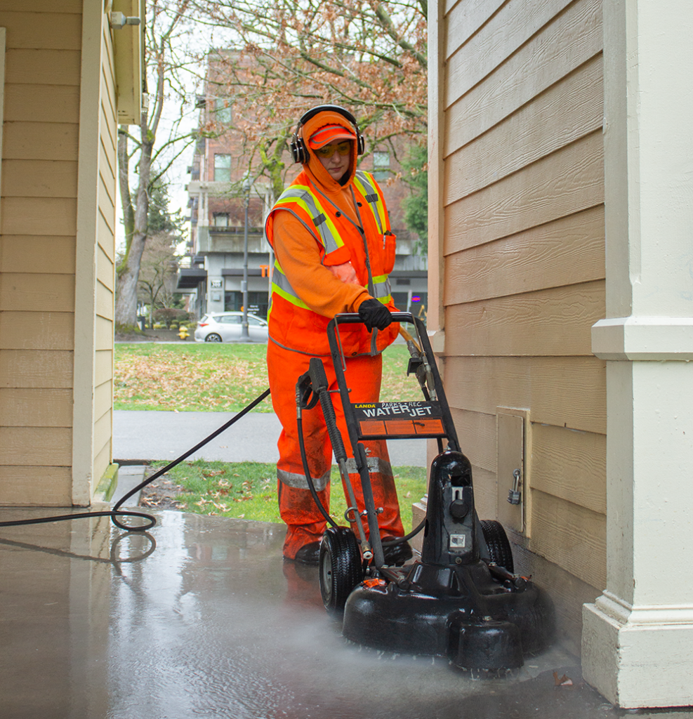 Aleesa wears safety gear as she pressure washes at Esther Short Park