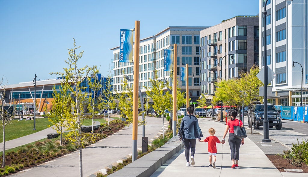 Two girls and child walking on the waterfront during a clear warm day