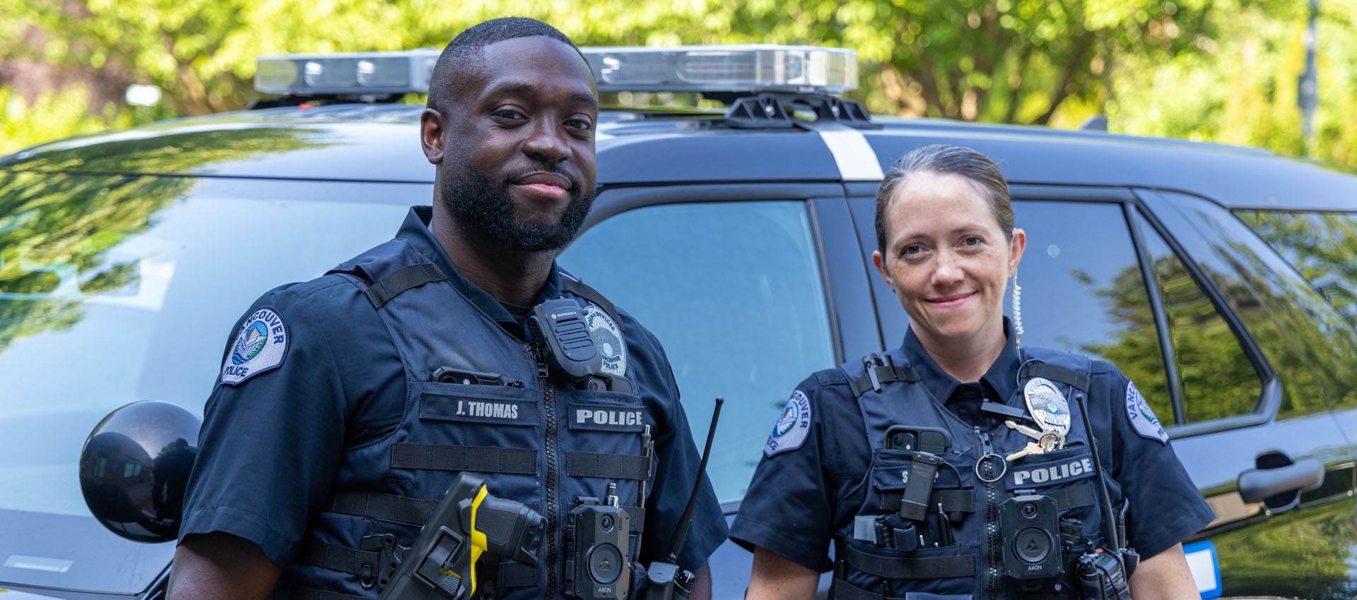 VPD officers smile in front of patrol car