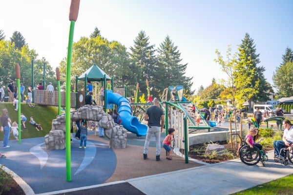 View of new Oakbrook Park playground with visitors of all ages, abilities