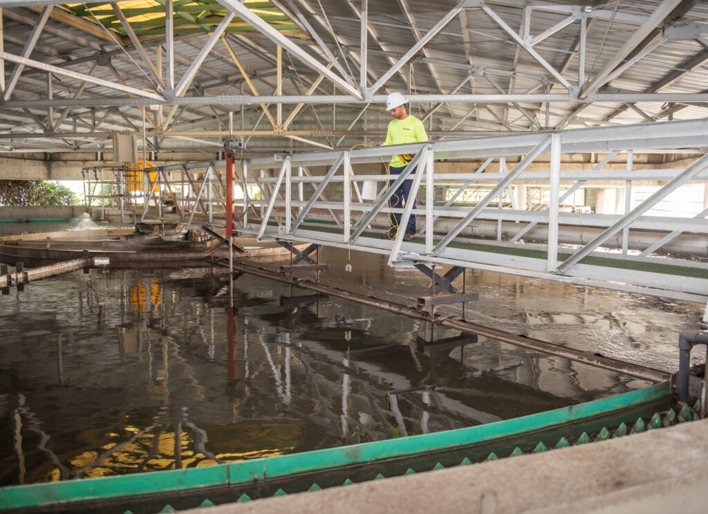 Wastewater Operator collecting water data above the Secondary Clarifier