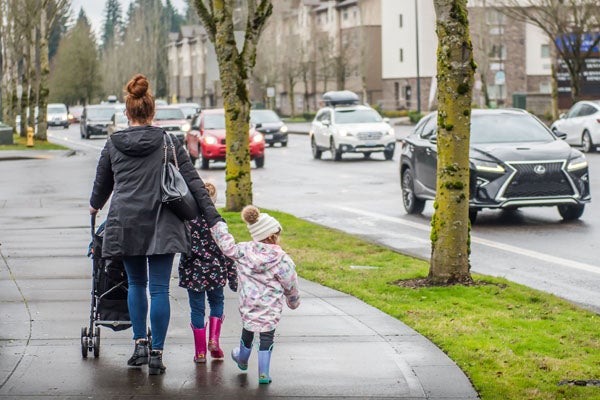 Mom walking with two children and stroller