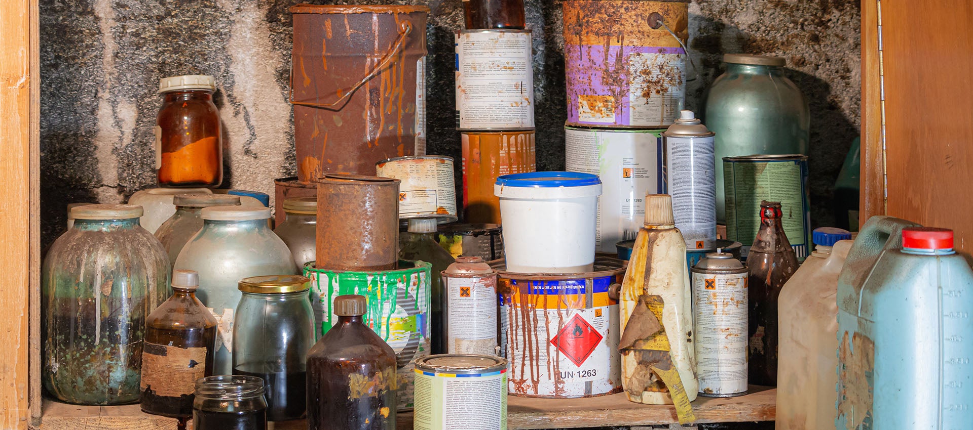 Household hazardous waste in a storage closet including paint and chemicals.