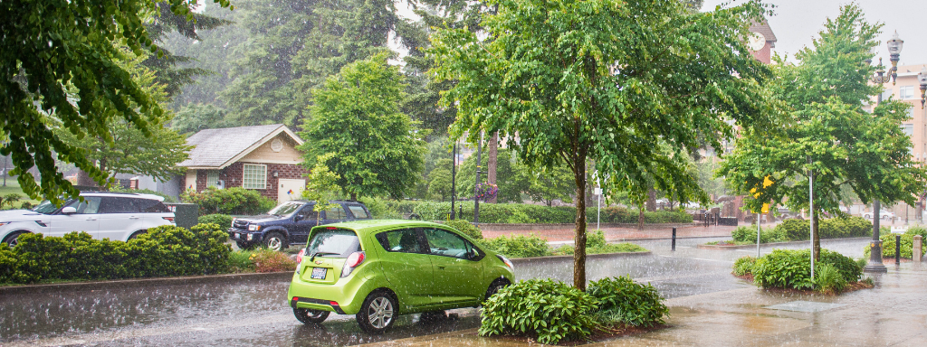 Heavy rain pours on parked cars outside City Hall.