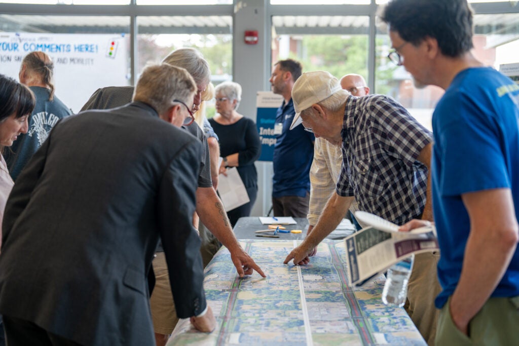 Community members point at locations along a map of Northeast 192nd Avenue.