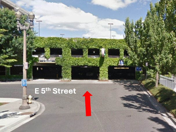 Google maps street view of the entrance of the 500 Broadway Parking Garage, a red arrow indicating the entry point on East 5th Street.