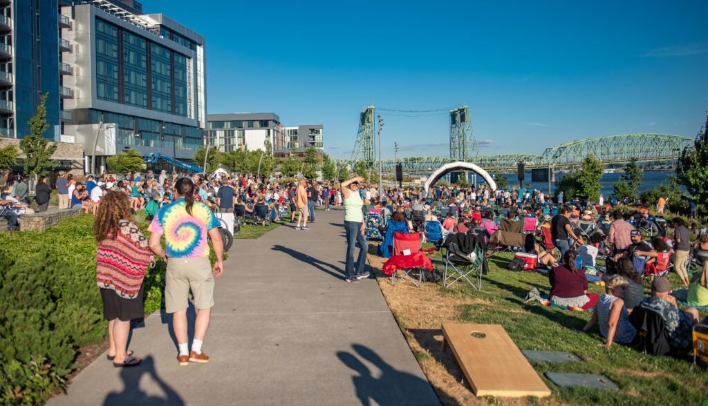 People gathering on the lawn for a concert.