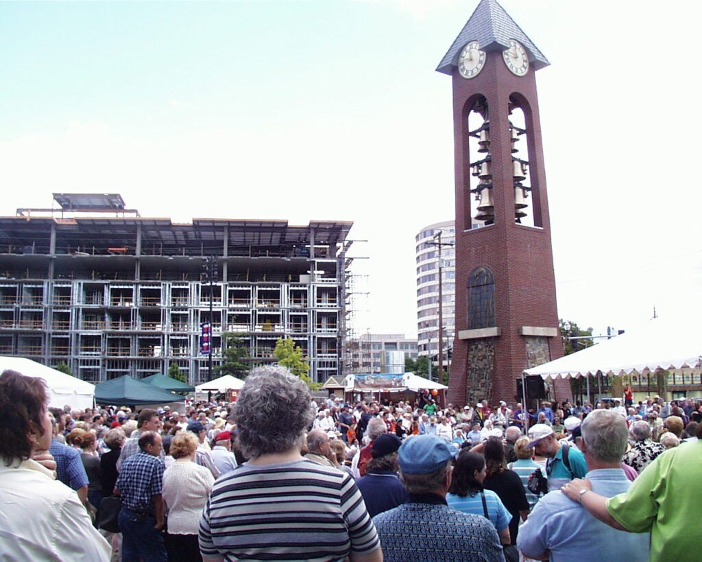 Crowd gathered around the brick Salmon Run Bell Tower in Esther Short Park.