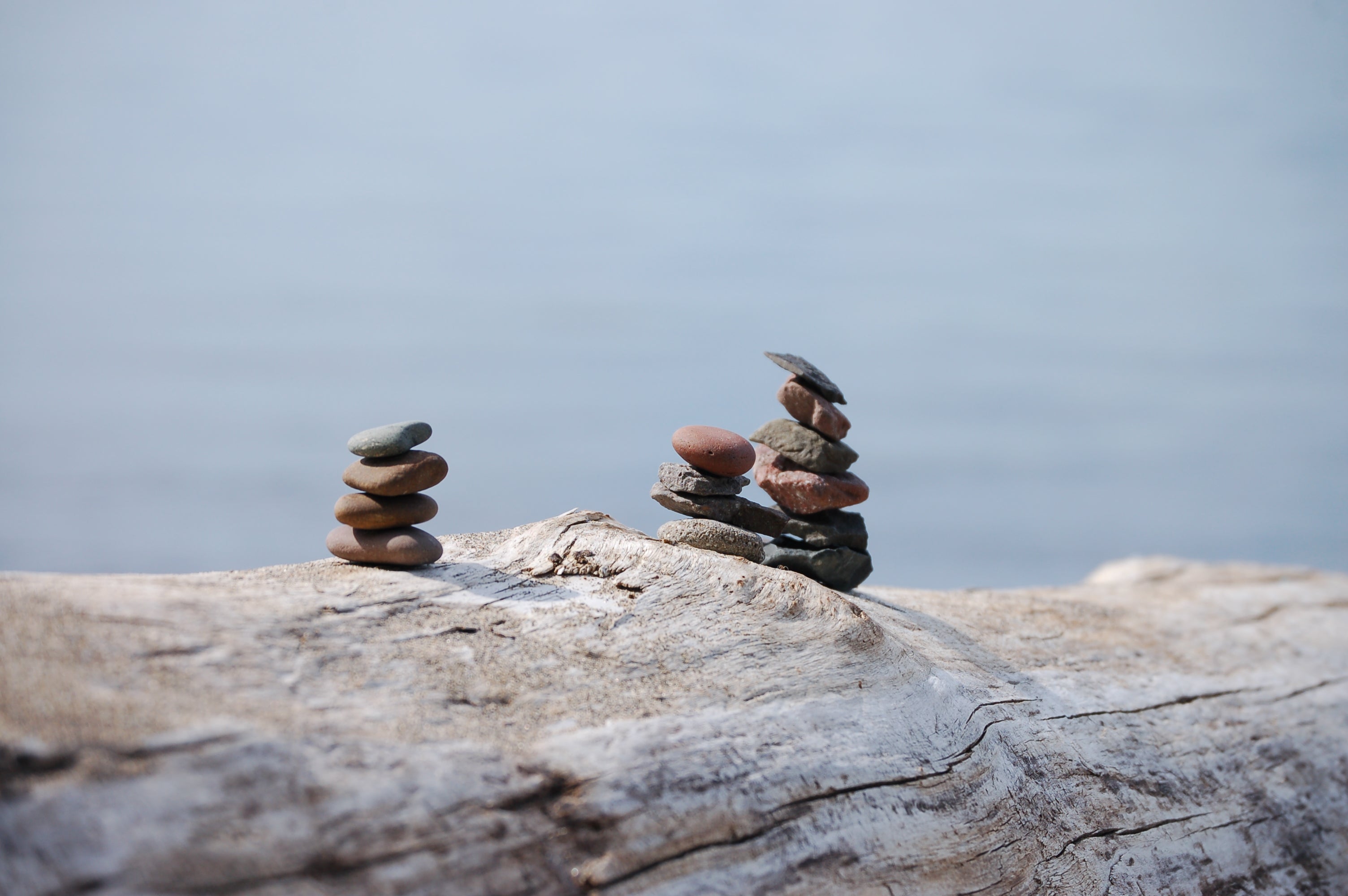 Rock cairns as nature art, on a log, by the river