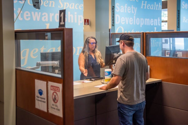 A City of Vancouver employee with the permit center assists a customer.