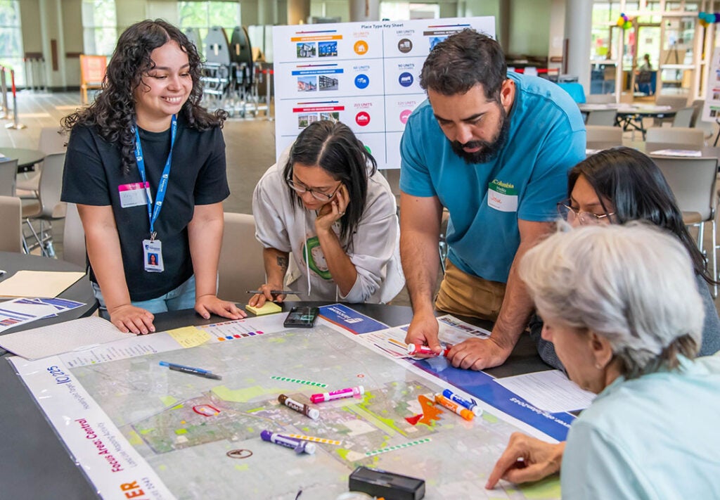 People gather around a map activity for Our Vancouver.