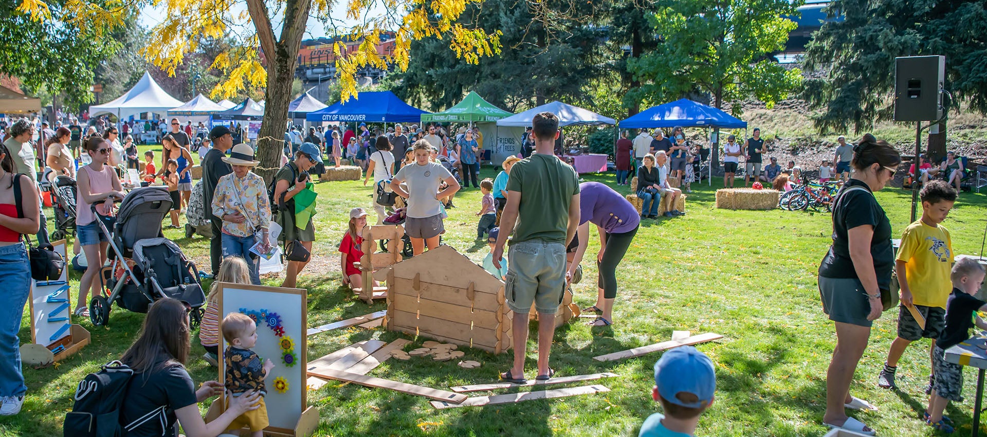 Kids play and adults mingle and look at booths at the Old Apple Tree Festival.